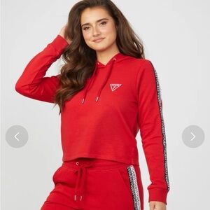 red Guess hoodie with logo tape detailing on the sleeves.